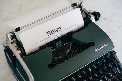 Skrivemaskine med papir hvor der står news